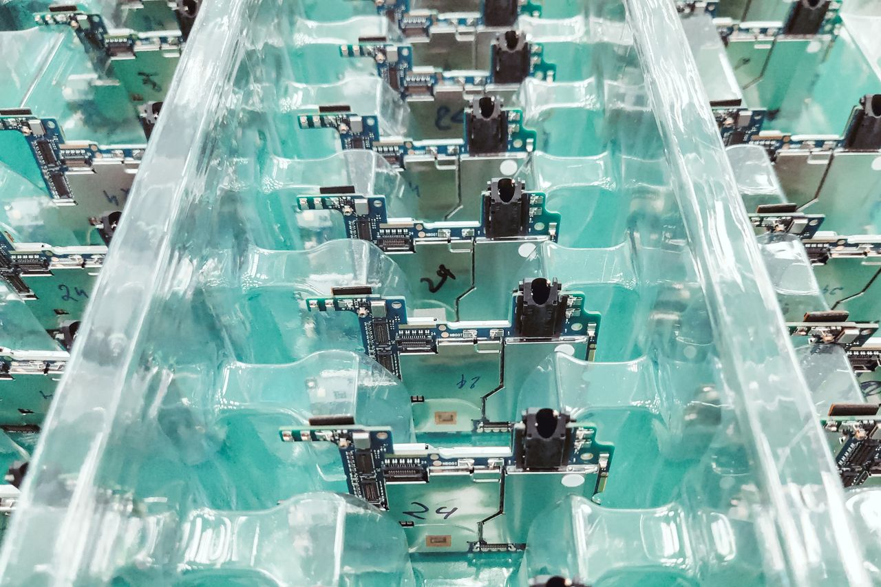 Portfolio Detailed view of organized electronic circuit boards in a production setting.